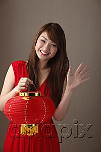AsiaPix - Young woman wearing red dress, holding red lantern and waving