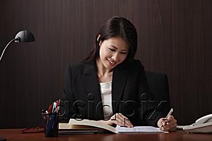 AsiaPix - Young woman writing at her desk