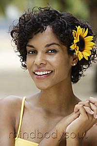 Mind Body Soul - woman smiling with yellow sunflower in her hair