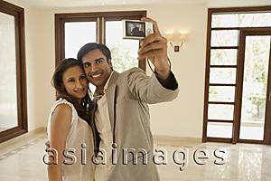 Asia Images Group - Young couple taking picture in empty home