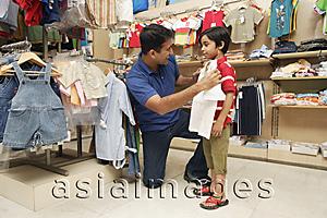 Asia Images Group - father and son shopping for clothes