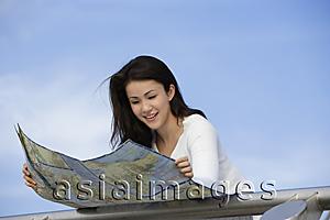 Asia Images Group - Young woman reading map