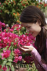 Asia Images Group - Young woman holding up flowers to smell