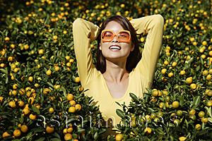 Asia Images Group - Young woman among orange plants
