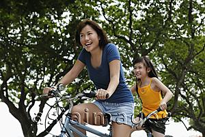 Asia Images Group - woman and young girl riding tandem bike