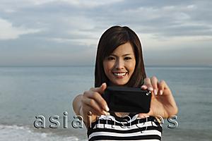 Asia Images Group - Young woman smiling through middle of inner tube