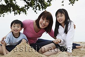 Asia Images Group - Young woman with boy and girl playing in sand