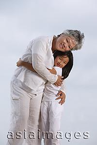Asia Images Group - Older woman and young girl hugging.