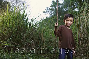 Asia Images Group - Boy holding stick.