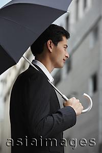 Asia Images Group - side profile of businessman holding umbrella
