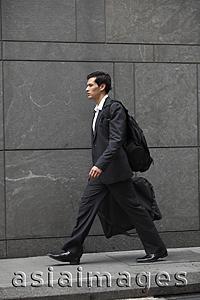 Asia Images Group - businessman walking holding briefcase, carrying back pack