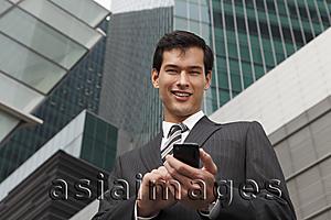 Asia Images Group - business man in a suit using mobile phone