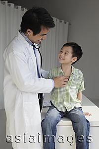 Asia Images Group - Doctor listening to young boy's heart and smiling at eachother