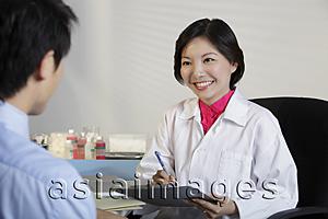 Asia Images Group - Woman doctor looking at patient and smiling