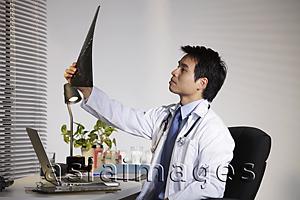 Asia Images Group - Doctor looking at X ray.