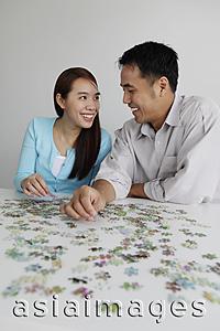 Asia Images Group - Young couple working on puzzle together