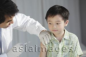 Asia Images Group - Doctor giving young boy a injection