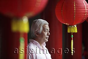 Asia Images Group - Profile of older man looking at Chinese temple