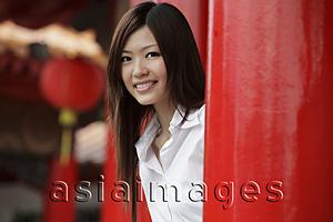 Asia Images Group - Young woman smiling at camera in front of Chinese temple