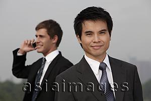 Asia Images Group - Chinese business man in foreground, Caucasian man on phone in background