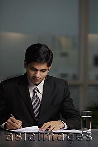 Asia Images Group - Indian man writing at table