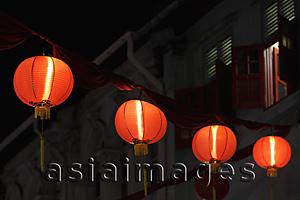Asia Images Group - Red lanterns glowing at night above the street