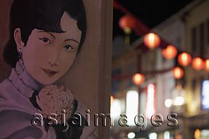 Asia Images Group - Poster of Chinese woman's face on wall with lanterns in background