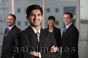 Asia Images Group - Indian man smiling in front of his colleagues