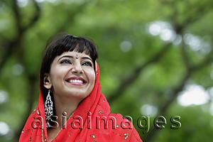 Asia Images Group - Head shot of Indian woman smiling with red sari over her head