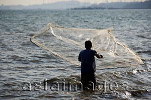 Asia Images Group - Man throwing net into the sea, Thailand