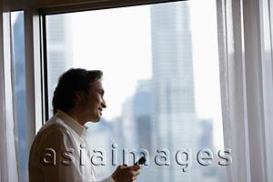 Asia Images Group - Man looking out of window smiling