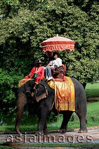 Asia Images Group - Tourist riding an elephant in Thailand