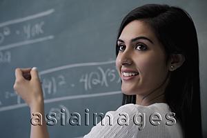 Asia Images Group - Close up of woman writing on chalk board and smiling