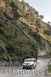 Asia Images Group - Men riding on the roof of a truck through the Himalayan Mountains, India