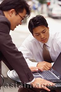 Asia Images Group - Two male executives working on laptop computer