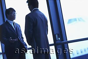Asia Images Group - Two male executives talking in airport, silhouette