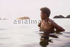 Asia Images Group - Young man standing in ocean, looking at horizon
