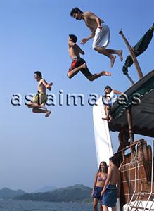 Asia Images Group - Teenagers jumping off yacht into water