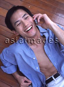 Asia Images Group - Man talking on cellular phone, laughing