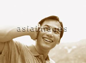 Asia Images Group - Man talking on cellular phone, smiling