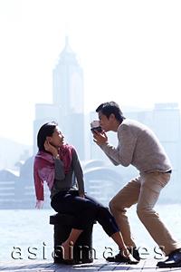 Asia Images Group - Couple by waterfront, man holding video camera