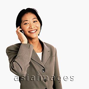 Asia Images Group - Female executive talking on cellular phone, white background