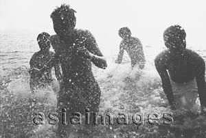 Asia Images Group - Teenagers splashing in the ocean, silhouette