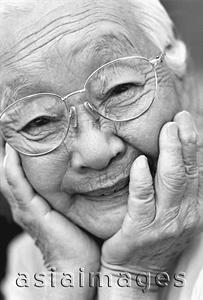 Asia Images Group - Mature woman resting chin on hands, smiling, portrait