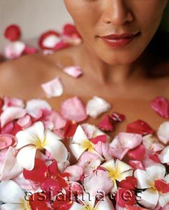 Asia Images Group - Woman relaxing in bathtub with flower petals