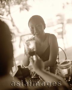 Asia Images Group - Woman holding wine glass sharing a toast.