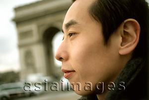 Asia Images Group - Profile of man, Arc de Triomphe in background.