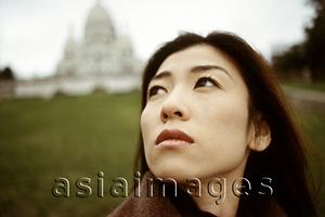 Asia Images Group - Woman looking up, building and lawn in background.