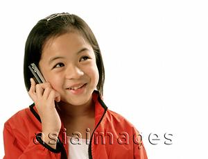 Asia Images Group - Young girl talking on cellular phone, white background.