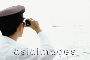 Asia Images Group - Man in white with binoculars, looking out to sea